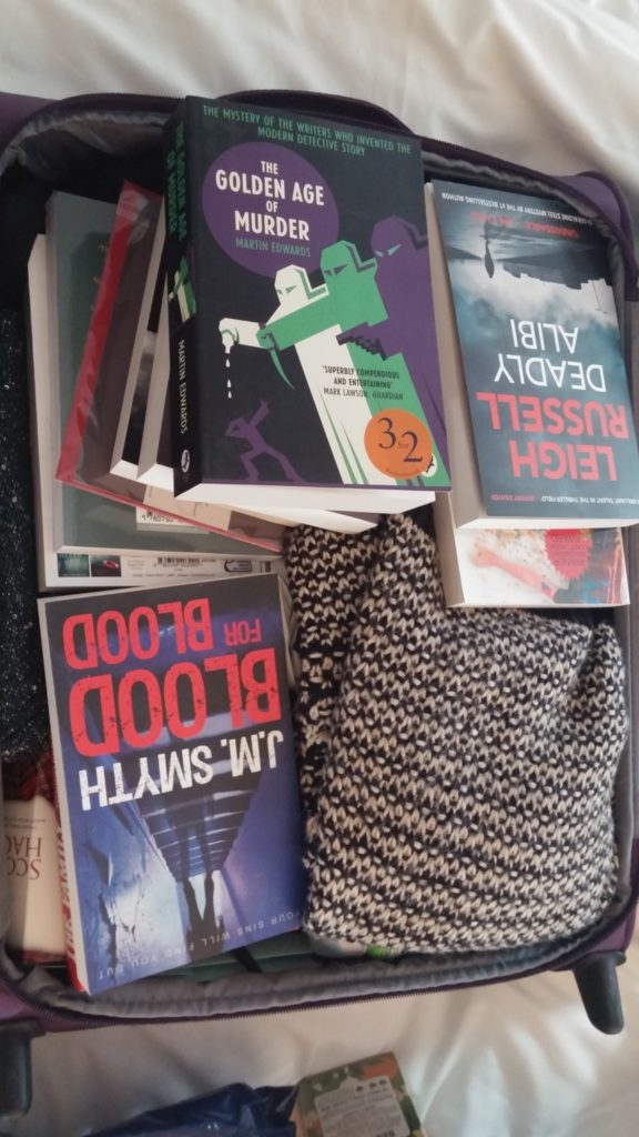 A suitcase full of books, with a jumper that just happened to be there.