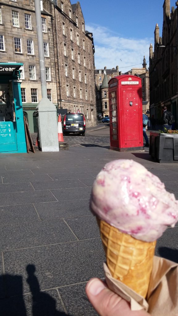 An ice-cream cone, a red phone box, old Edinburgh buildings in the background.