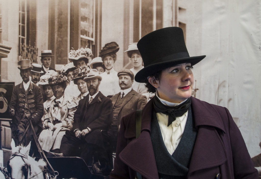 Me in a top hat, trying to look like a Victorian professor, in front of a large sepia print photo of a street scene