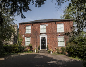 A double-fronted red brick house.